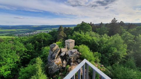 View from Spitzer Stein over the green Middle Rhine Valley and the old signal house, surrounded by lush nature and gentle hills.